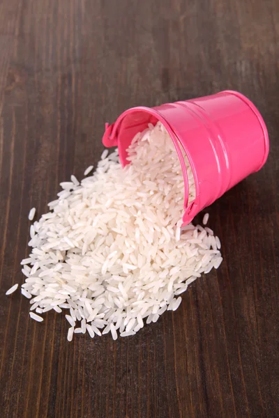 Overturned bucket with grains on wooden background — Stock Photo, Image