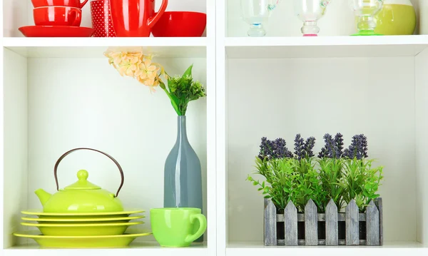 Beautiful white shelves with tableware and deco — Stock Photo, Image