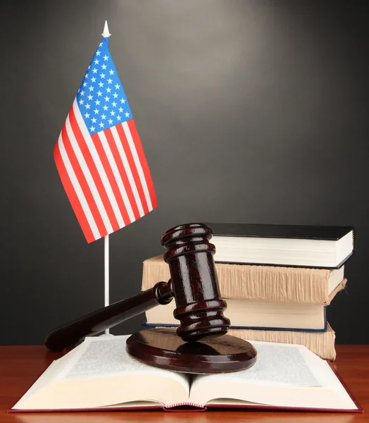 Wooden gavel, books and American flag on grey background — Stock Photo, Image