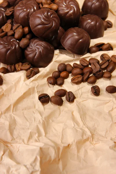 Bonbons au chocolat et grains de café, sur papier beige — Photo