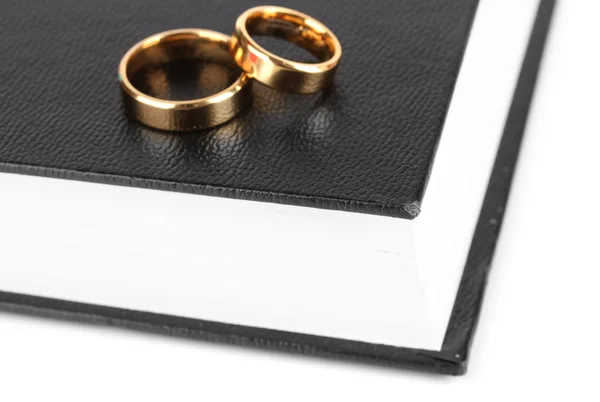Anéis de casamento na bíblia isolados no branco — Fotografia de Stock