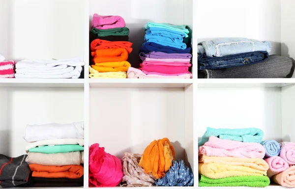 Ubrania starannie złożone na półkach — Zdjęcie stockowe