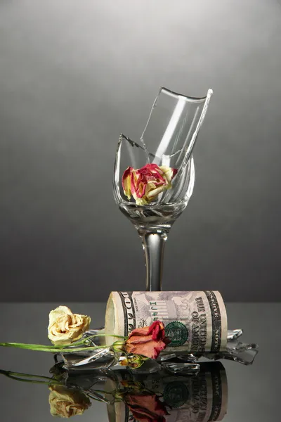 Broken wineglass and money on grey background — Stock Photo, Image