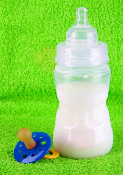 Bottle for milk and nipple on towel background — Stock Photo, Image