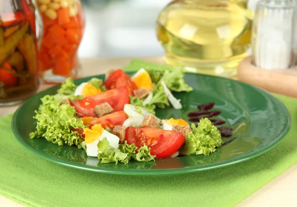 Fresh mixed salad with eggs, tomato, salad leaves and other vegetables on color plate, on bright background — Stock Photo, Image