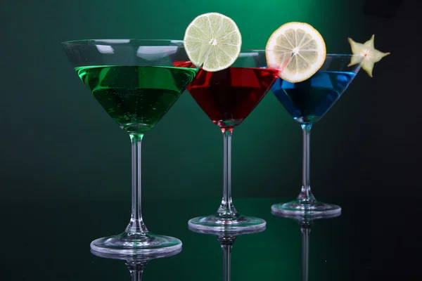 Cócteles alcohólicos en vasos de martini sobre fondo verde oscuro —  Fotos de Stock