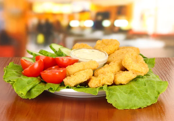 Fried chicken nuggets with vegetables and sauce on table in cafe — Stock Photo, Image