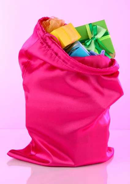 Rosa Tasche mit Geschenken auf rosa Hintergrund — Stockfoto