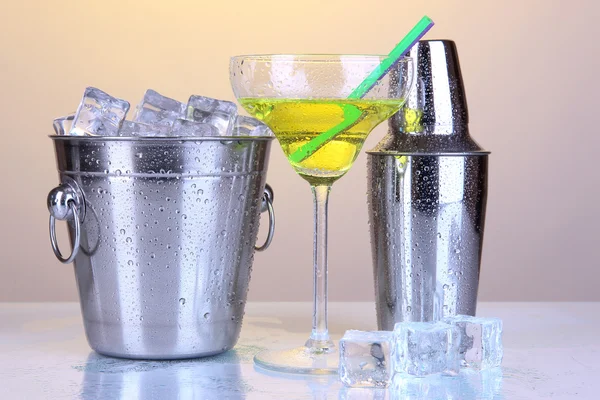 Metal ice bucket and shaker and cocktail on yellow background — Stock Photo, Image