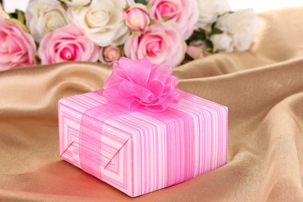 Beautiful gift on flowers background — Stock Photo, Image