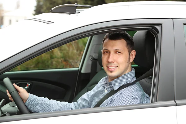 Retrato del joven sentado en el coche — Foto de Stock