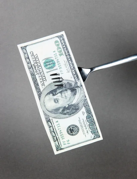 Banknotes on fork on grey background Stock Image