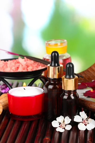 Wellness-Komposition mit Aromaölen auf Tisch auf hellem Hintergrund — Stockfoto