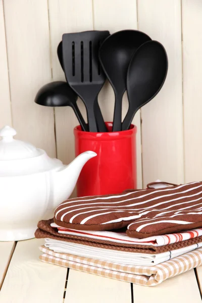 Kitchen settings: utensil, potholders, towels and else on wooden table — Stock Photo, Image