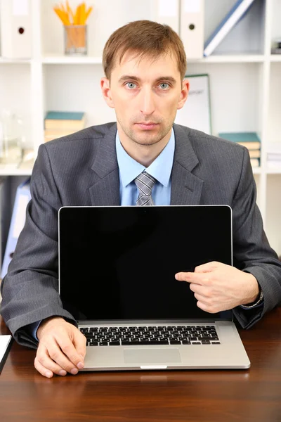 Jeune homme d'affaires avec ordinateur portable face à son lieu de travail — Photo