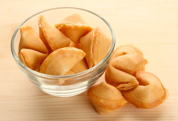 Fortune cookies in bowl, on wooden table — Stock Photo, Image