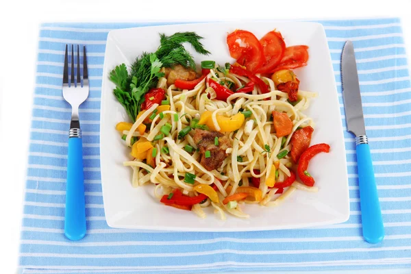 Noodles with vegetables on plate on napkin — Stock Photo, Image