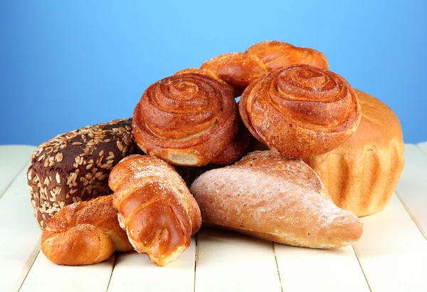 Komposition mit Brot und Brötchen auf Holztisch, auf farbigem Hintergrund — Stockfoto