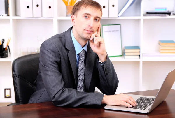 Young businessman in office at his workplace — Stock Photo, Image