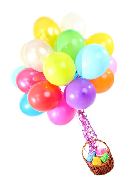 Many bright balloons and basket with gifts isolated on white — Stock Photo, Image