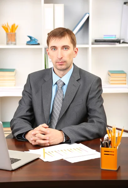 Jonge zakenman in kantoor op zijn werkplek — Stockfoto