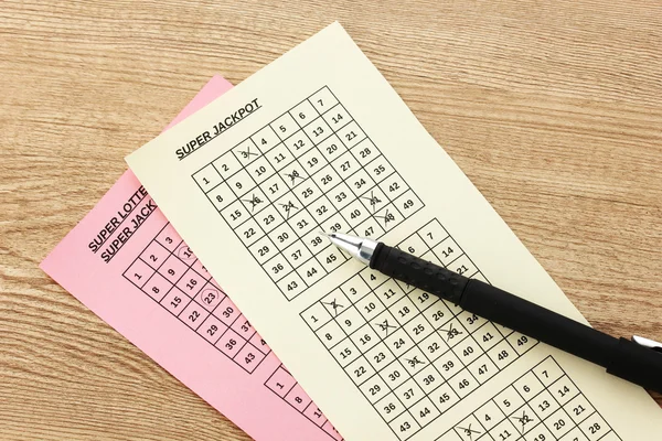 Lottery tickets and pen, on wooden background — Stock Photo, Image