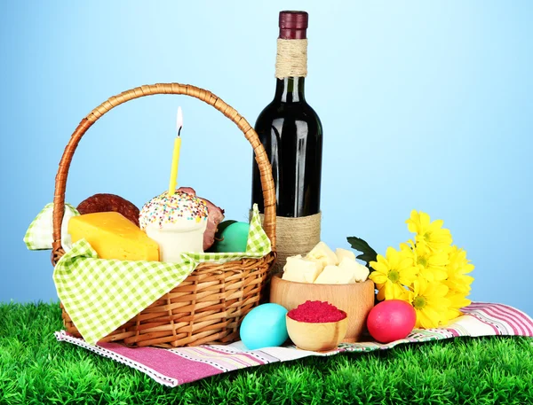 Easter basket: Conceptual photo of traditional easter food in wicker basket, on green grass, on color background — Stock Image Easter basket: Conceptual photo of traditional easter food in wicker basket, on green grass, on color background Royalty Free Stock Images