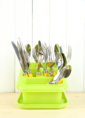 bıçak, kaşık, çatal plastik kap içinde renk ahşap arka plan üzerinde kurutma