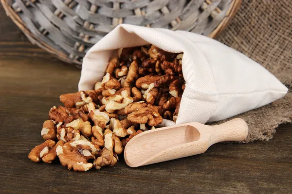 Орехи в мешке на деревянном фоне — стоковое фото
