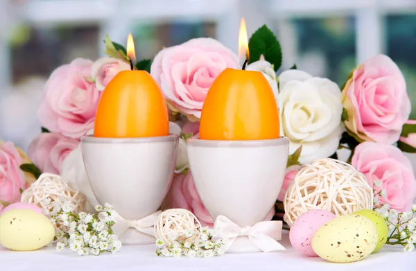 Easter candles with flowers on window background — Stock Photo, Image