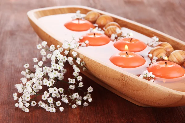 Piękne świece w wodzie na drewniany stół szczegół — Zdjęcie stockowe