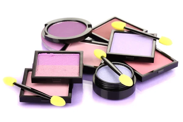 Sombras de olhos brilhantes e escovas de esponja para fundação em fundo lilás — Fotografia de Stock