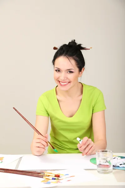 Hermosa joven pintora en el trabajo, sobre fondo de color —  Fotos de Stock