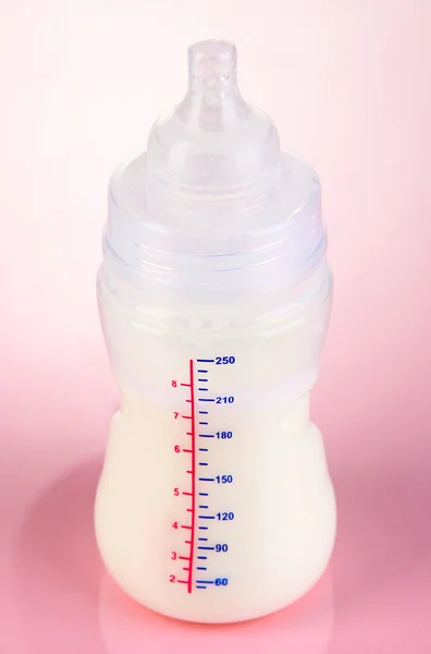 Fles voor melk formule op roze achtergrond — Stockfoto