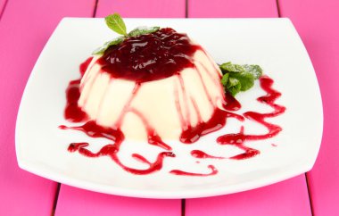 Panna cotta renk ahşap zemin üzerinde frambuaz sos ile