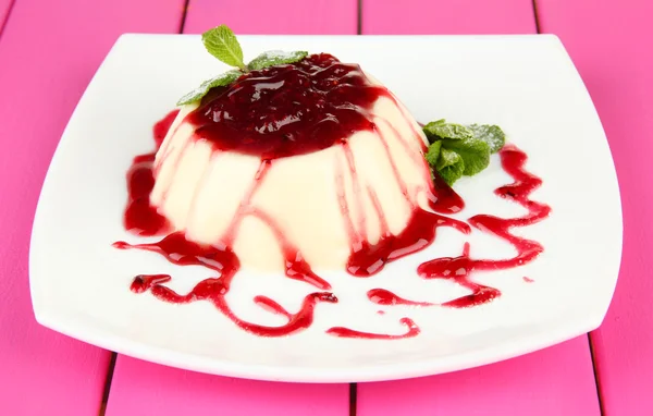 Panna Cotta with raspberry sauce, on color wooden background — Stock Photo, Image