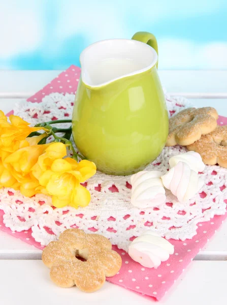 Hermosa composición de leche y galletas en mesa de picnic de madera sobre fondo natural —  Fotos de Stock