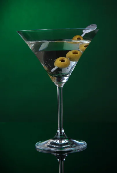 Martini glass with olives on dark green background — Stock Photo, Image