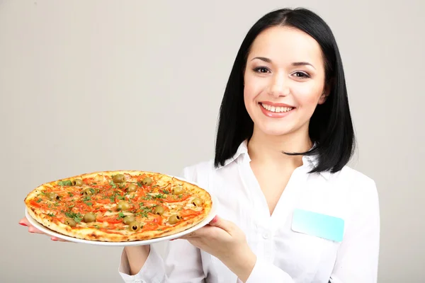 Belle fille serveur avec pizza isolé sur blanc — Photo