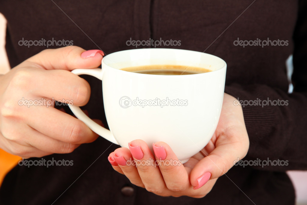 Hands holding mug of hot drink, close-up