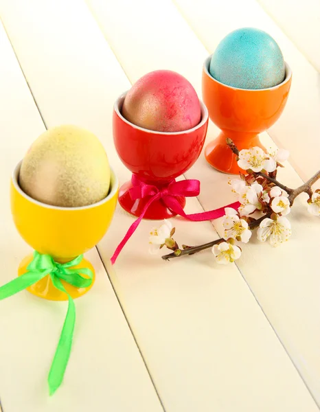 Ovos de Páscoa em bandejas coloridas na mesa de madeira — Fotografia de Stock