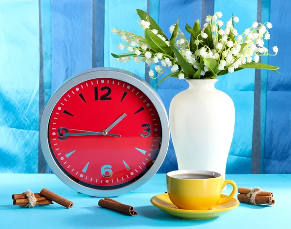 Cup coffee and clock on bright background — Stock Photo, Image