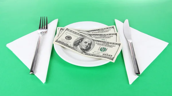 Dinero en plato sobre fondo verde — Foto de Stock