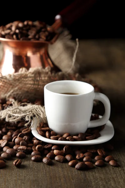 Kopp kaffe och potten på trä bakgrund — Stockfoto