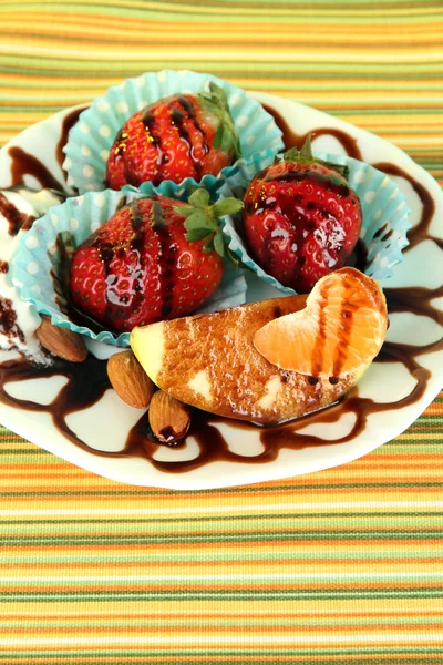 Fruit in chocolate on plate on tablecloth close-up — Stock Photo, Image