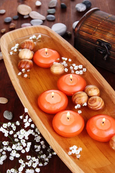 Beautiful candles in water on wooden table close-up — Stock Photo, Image