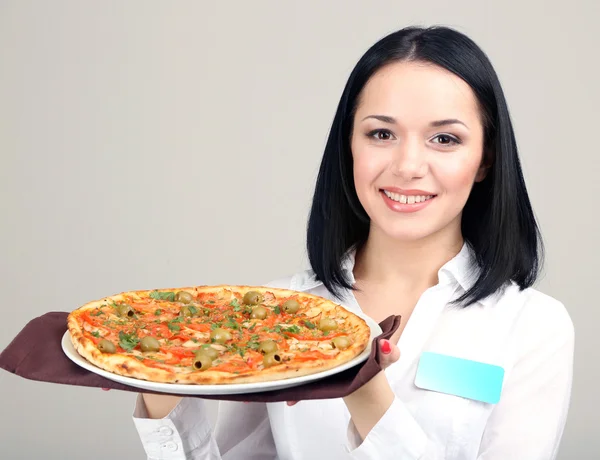Hermosa chica camarera con pizza aislada en blanco — Foto de Stock