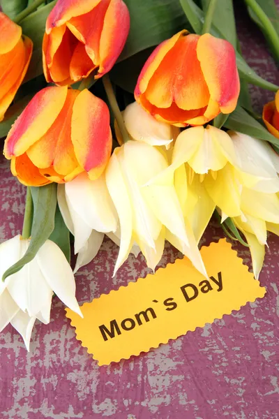 Krásné bílé a oranžové tulipány na barevné dřevěné pozadí — Stock fotografie