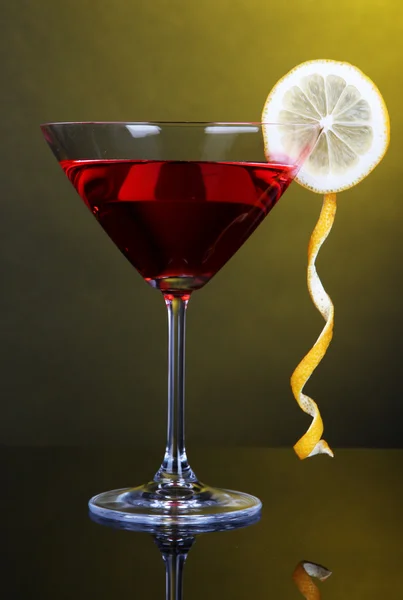 Red cocktail in martini glass on dark yellow background — Stock Photo, Image