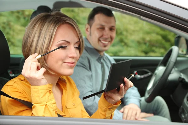 Casal sentado no carro (mulher aplicando maquiagem ) — Fotografia de Stock